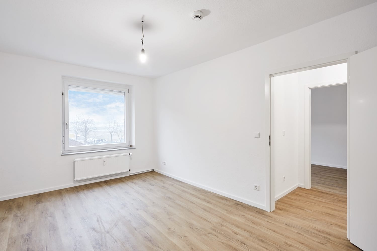 Zimmer mit Fenster und Durchgang zum Flur