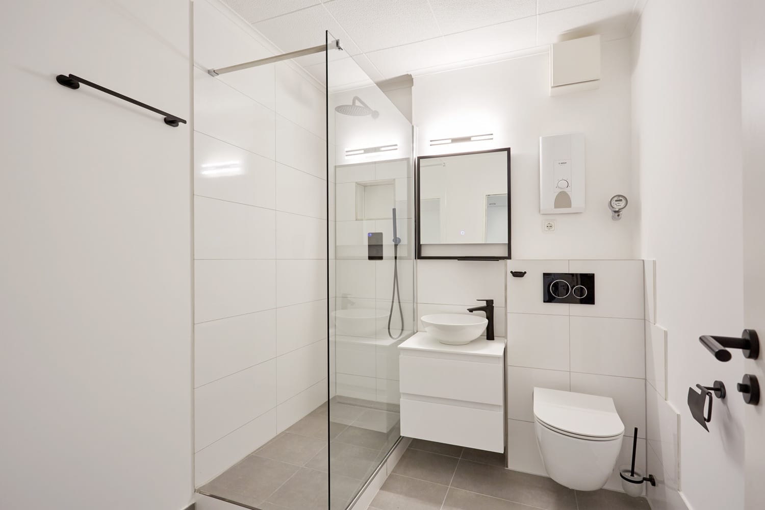 Badezimmer mit Walk-in-Dusche und schwarzen Armaturen