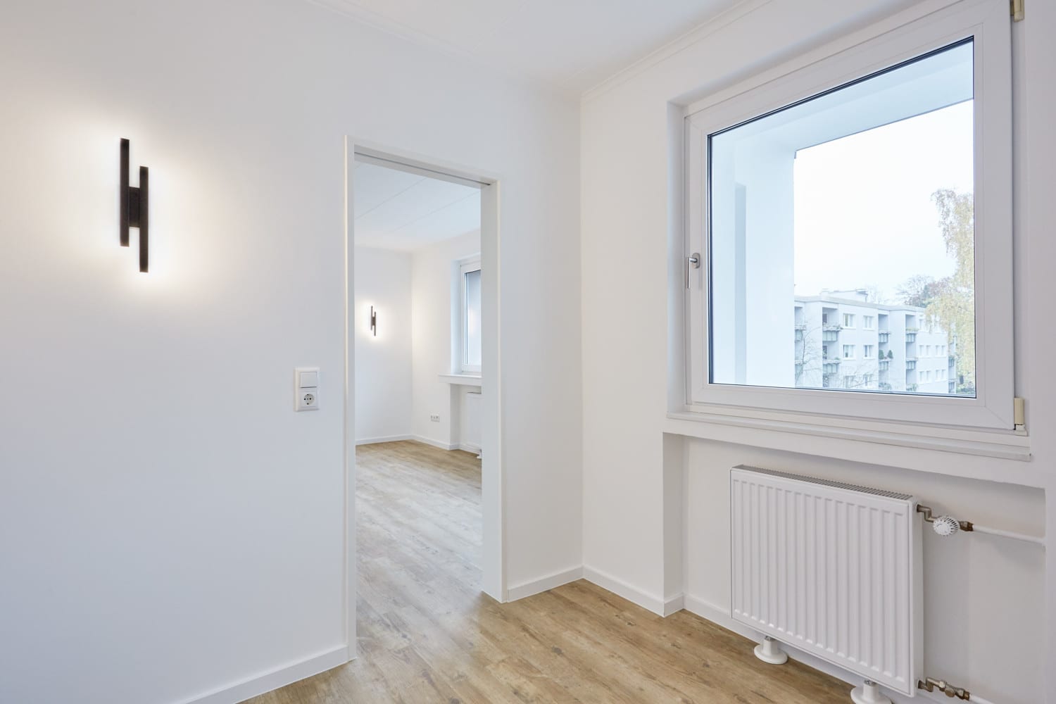 Schlafbereich mit Fenster und Wandleuchte