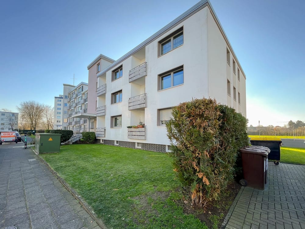 Wohnhaus mit Rasenfläche und Hecke von der Straße aus