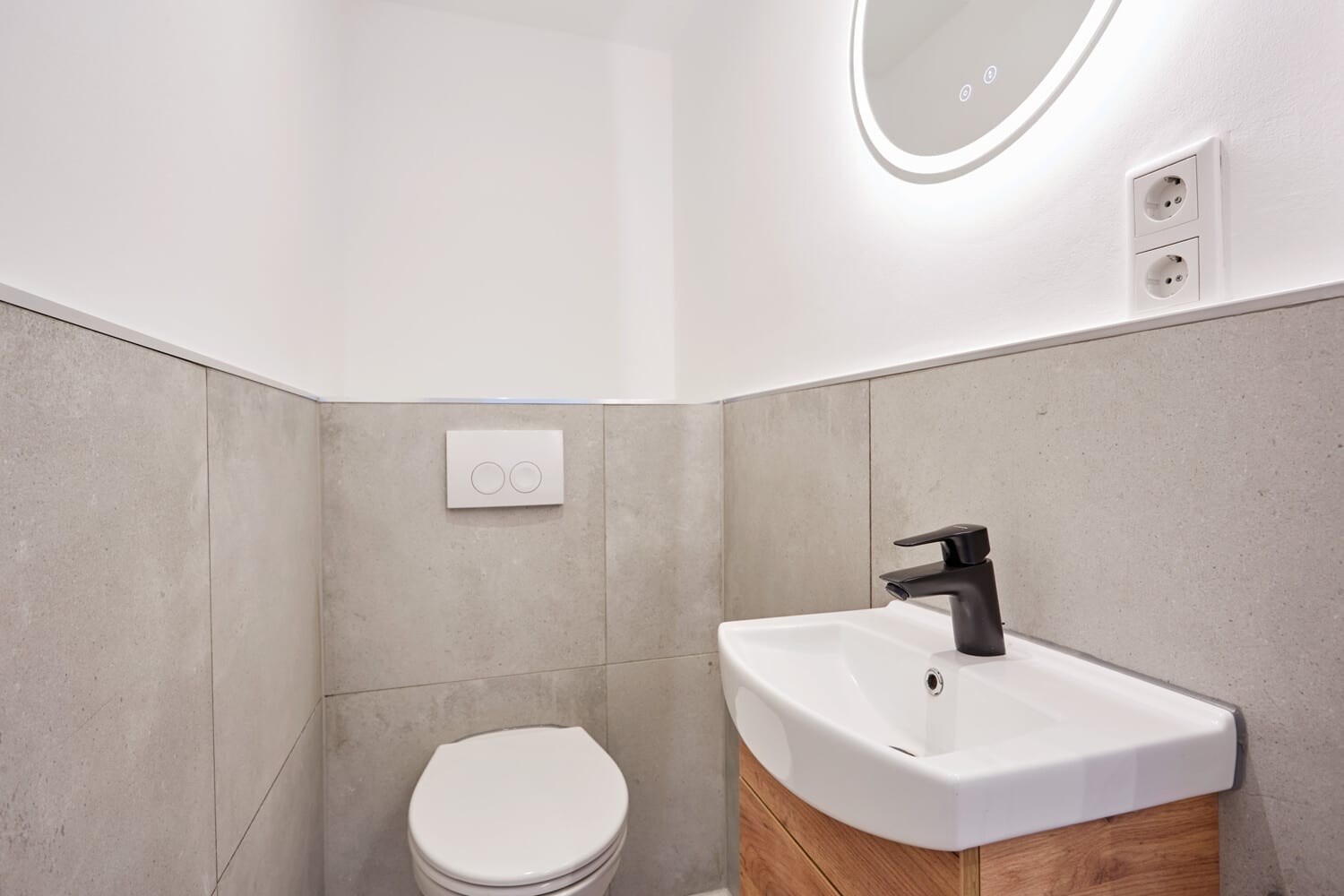 Gäste-WC mit rundem Spiegel und Holzwaschtisch