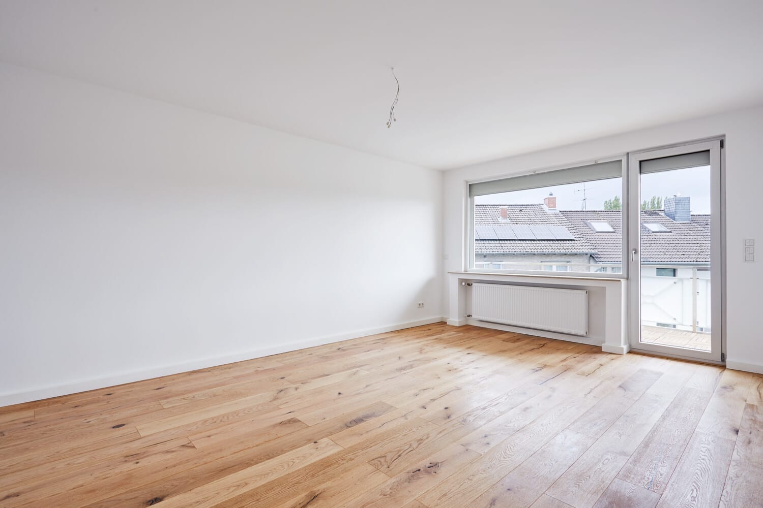 Wohnraum mit Balkontür und Eichendiele