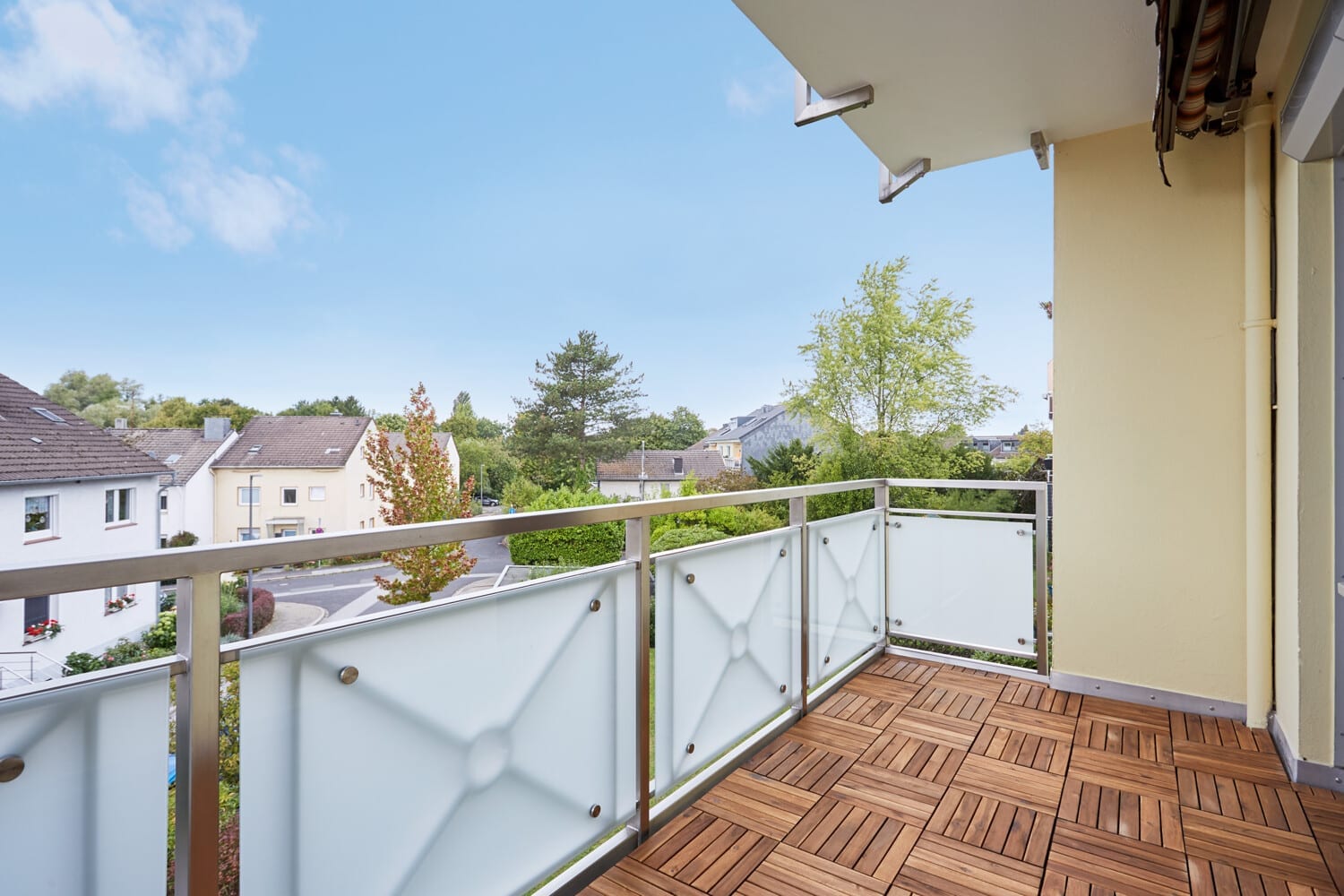 Balkon mit Holzbelag und Blick über die Dächer