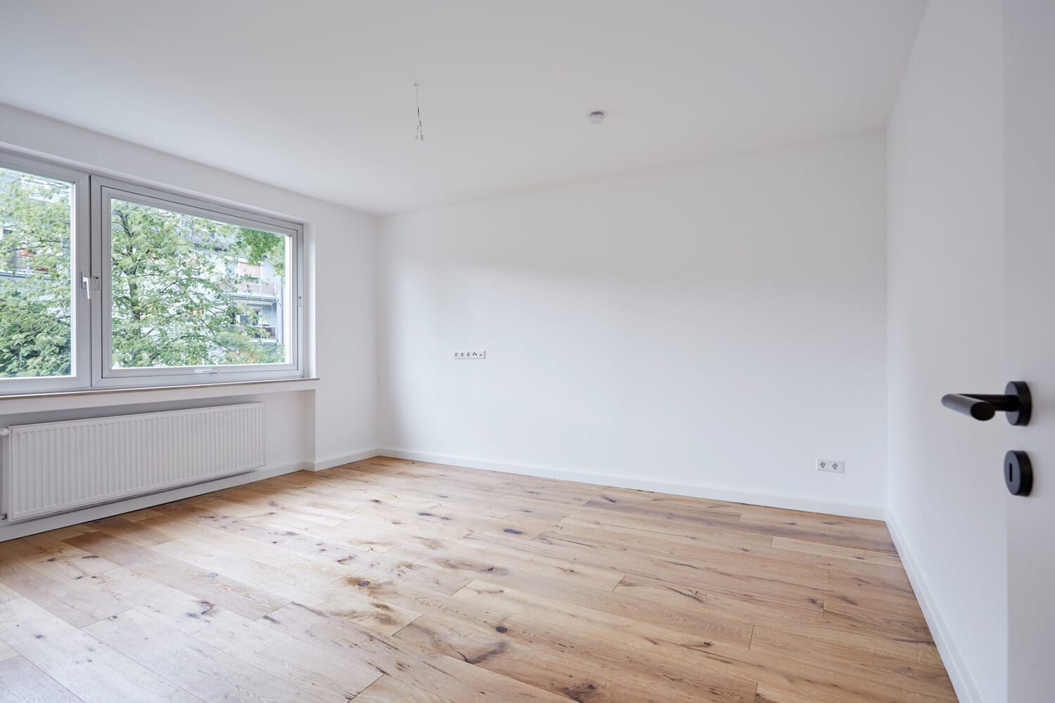 Zimmer mit breitem Fenster und Heizkörper