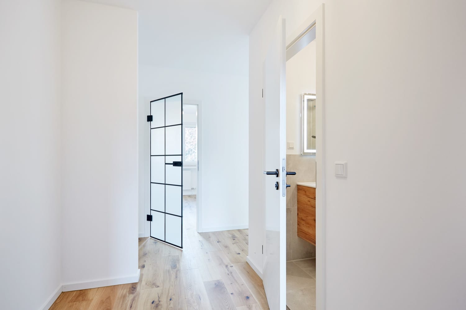 Flur mit Blick durch die Glastür in das Badezimmer