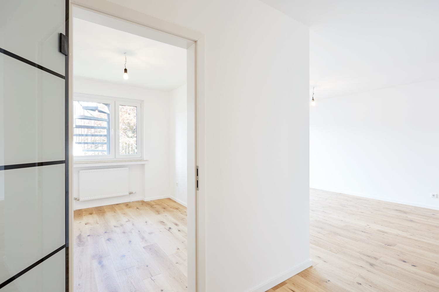 Schwarz gerahmte Glastür zwischen Flur und Zimmer