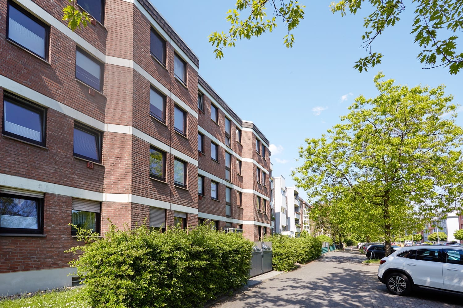 Gebäudezeile mit Baumbestand von der Straße aus